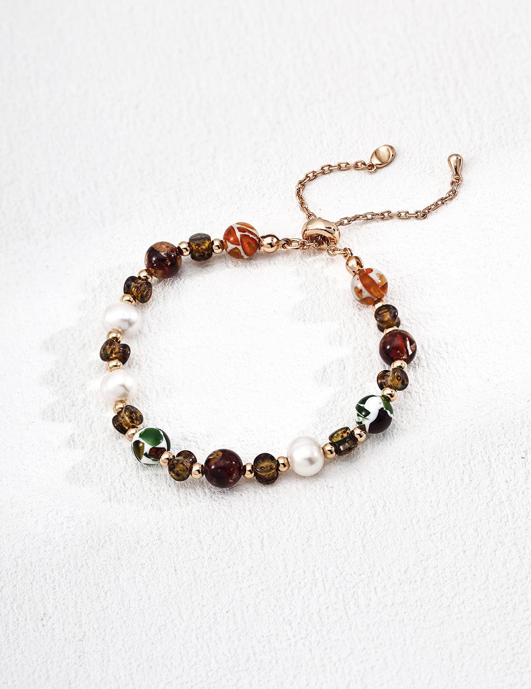 Handcrafted with pearls, glass and shell — quiet harmony in color and light