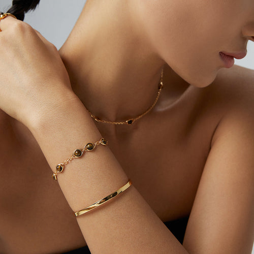 Modell trägt offene Armspange in Gold mit Kugelenden