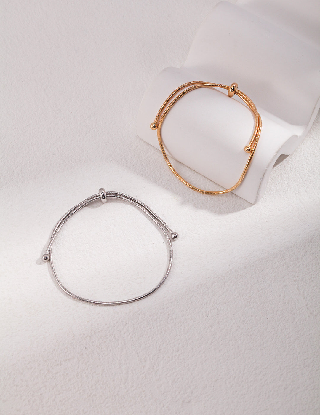 Goldene und silberne Ausführung des SERENA-Armbands nebeneinander präsentiert